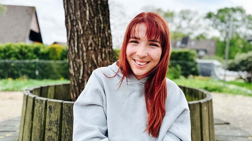 Eine Frau mit langen roten Haaren, Janine Stach.