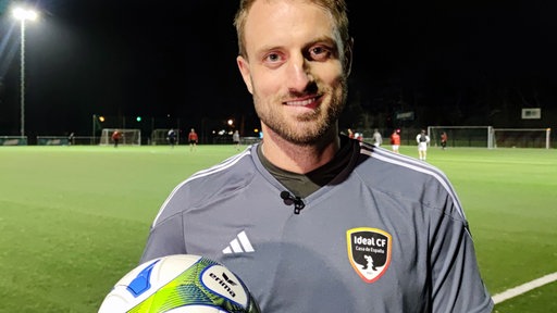 David Wick hält einen Fußball in der Hand