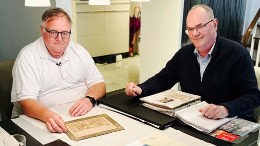 v. l. Matthias und Stefan Kullmann. Sie sitzen an einem Küchentisch.