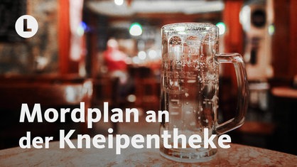 Ein leerer Bierkrug steht auf einem Tisch, im Hintergrund ist eine Kneipe von innen zu sehen
