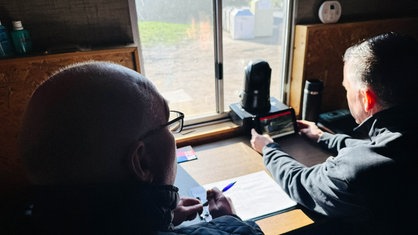 Zwei Männer sitzen in an einem Tisch, der vor einem Fenster steht. | Bildquelle: WDR/Markus Gröters Zwei Männer sitzen in an einem Tisch, der vor einem Fenster steht.