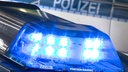Auf dem Foto ist ein Blaulicht der Polizei, dahinter die Aufschrift "Polizei" an einem Auto.