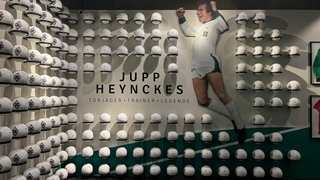 Wir sehen dutzende Bälle, die an der Wand hängen. Insgesamt sind es 299 Bälle. So viele, wie Heynckes Tore für Borussia geschossen hat.