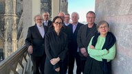 Ein Gruppenfoto der Künstlerin Andrea Büttner mit der Fachjury auf dem Kölner Dom 