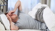 Ein Mann liegt in seinem Bett
