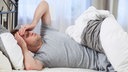 Ein Mann liegt in seinem Bett
