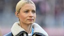 Die Sportjournalistin Lena Cassel trägt ein Headset und beobachtet ein Bundesliga-Spiel